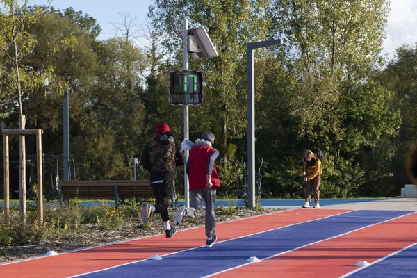 Due corridori sulla pista atletica a Saint-Dizier, con un dissuasore di velocità EVOLIS Vision che mostra una velocità di 17km/h.